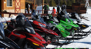 Various brands of snowmobiles parked against each other